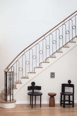 black iron curved stair rail and a wooden staircase