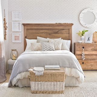 bedroom with white designed wall wooden bed and wooden drawers