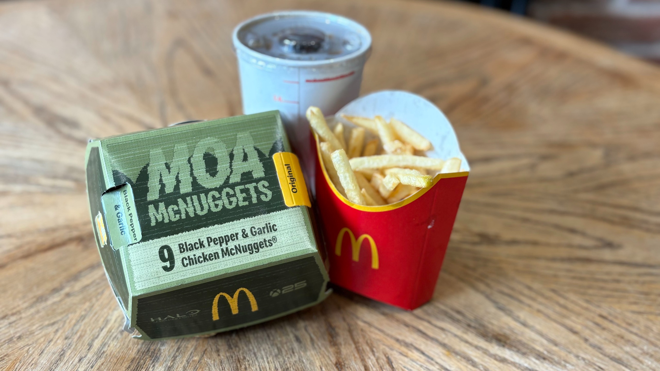 Close-up of a green McDonald's 9 Moa McNuggets box with Halo and Xbox 25th anniversary logos next to fries.