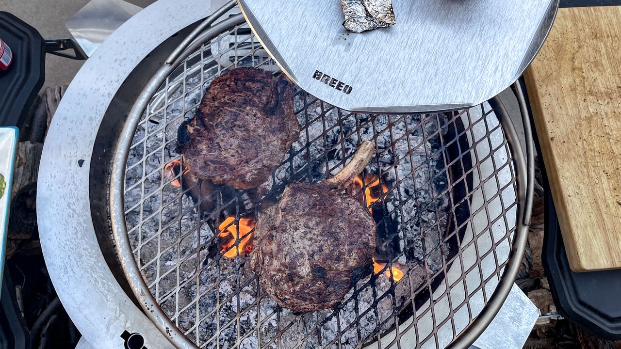 Breeo Live-Fire Grill grilling two steaks