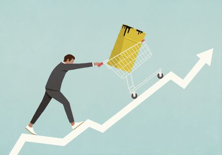 Businessman pushing oil barrel in shopping cart up line graph arrow 