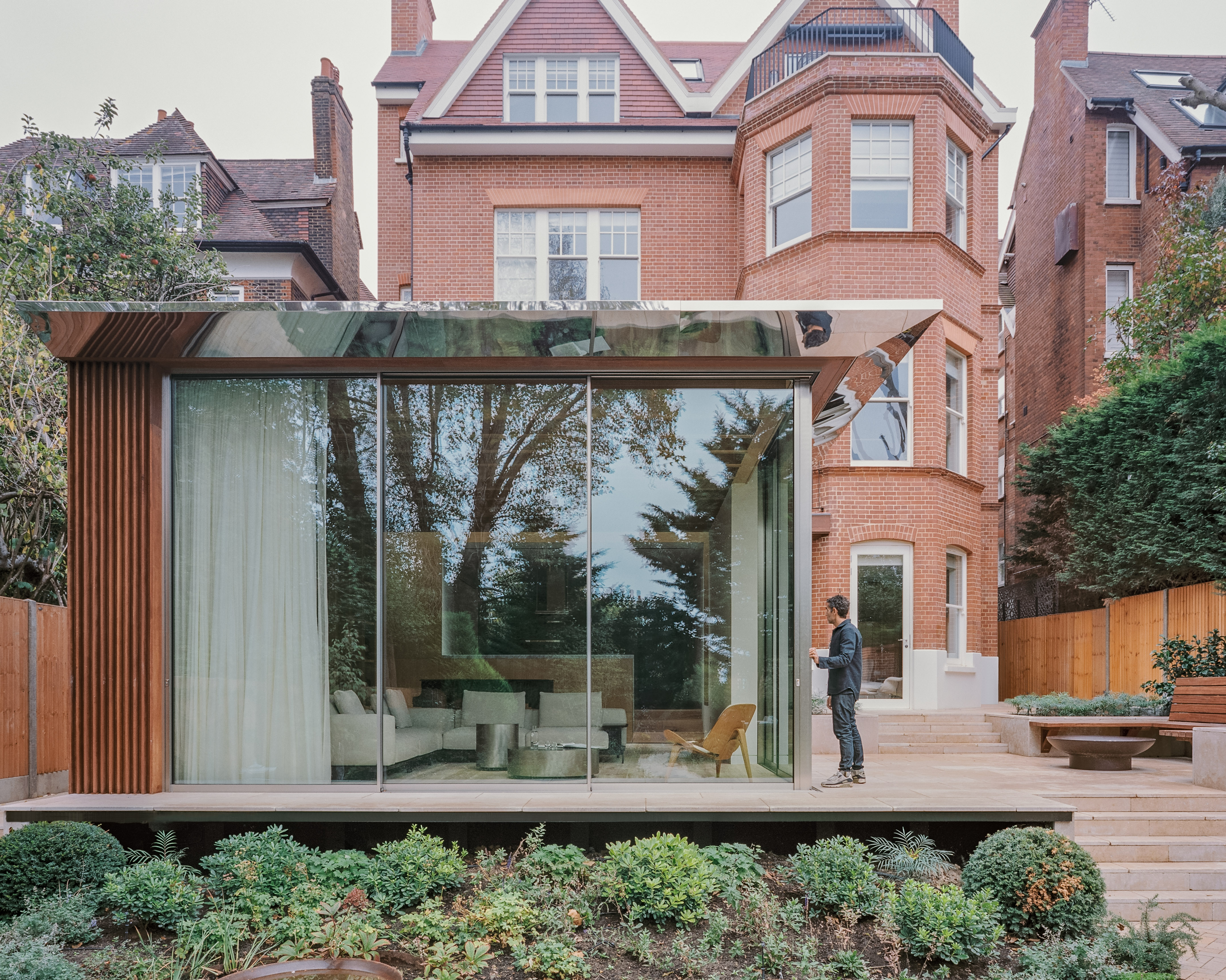 views of Panoramic House by Mata with a timber clad extension and built in furniture