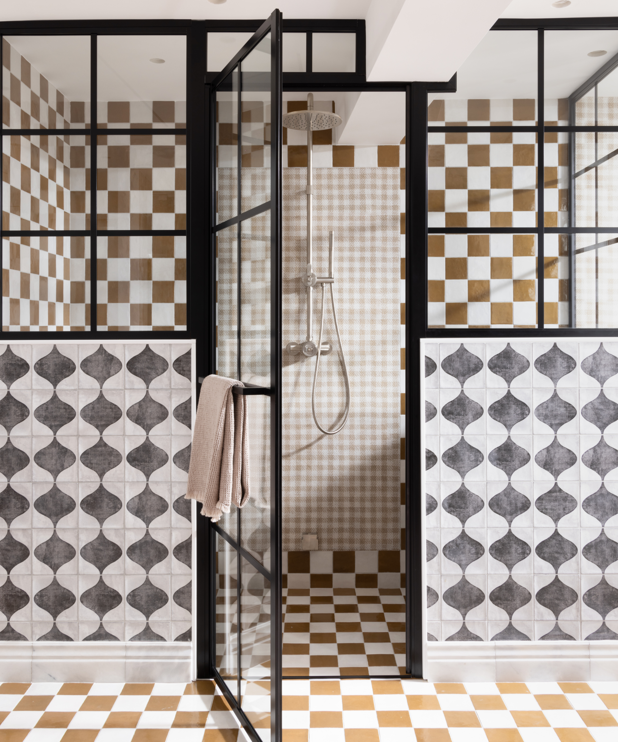 walk in shower with different coloured tiles and patterns on walls and floor