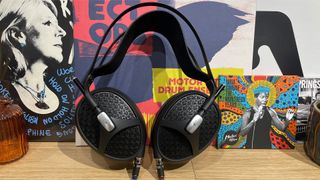 Meze Audio Empyrean II open-back headphones leaning upright on wooden shelf