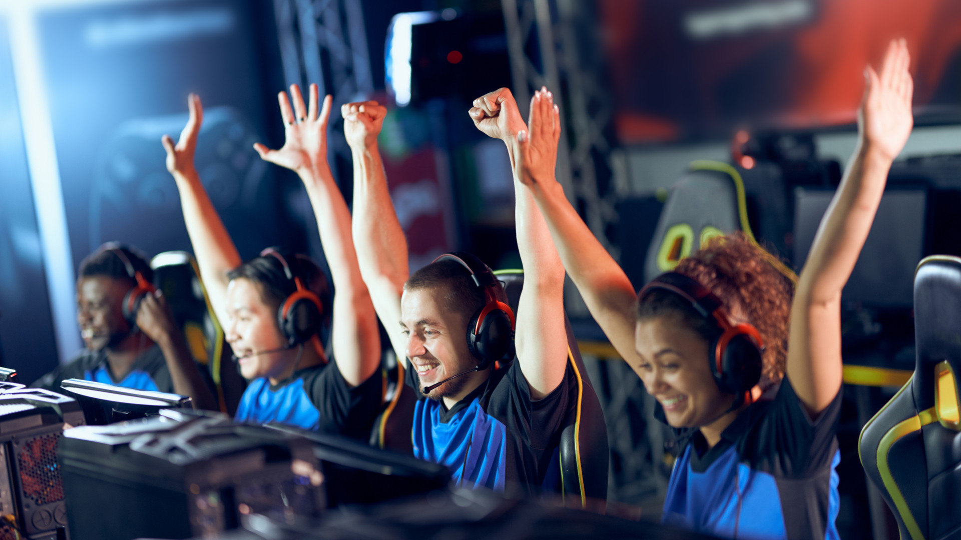 Happy pc gaming team throwing their hands in the air