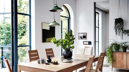 A dining room table with a light hanging over