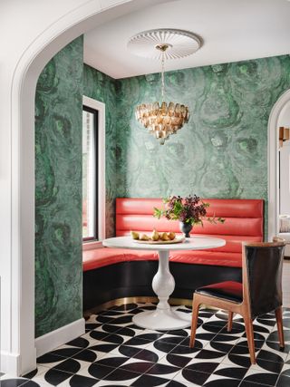 A vibrant banquette with a red sofa and green walls