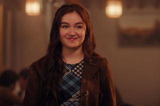 anna cathcart as kitty covey song in xo kitty season 2 smiling and wearing a suede blazer