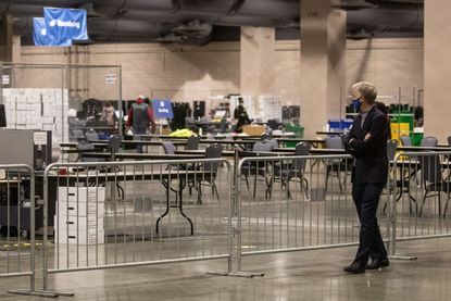 A man watches on from the observers area as election workers count ballots at the Philadelphia Convention Center