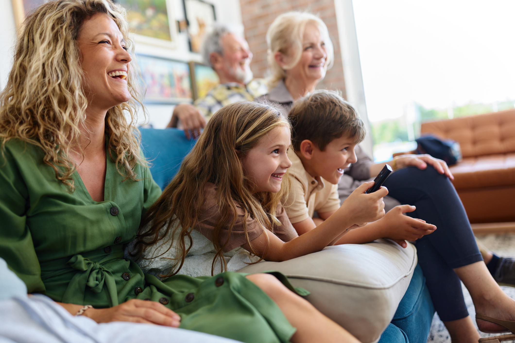 Happy extended family watching a movie on TV at home.