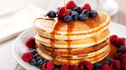 A stack of pancakes with berries.