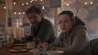 (L to R) Pedro Pascal as Joel and Bella Ramsey as Ellie eating a meal in The Last of Us episode 6.