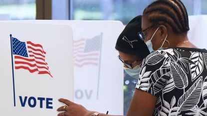 Two people cast their vote in the 2020 presidential election