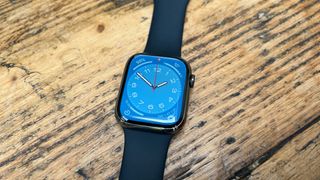 The Apple Watch Series 8 with a black strap laid on a table