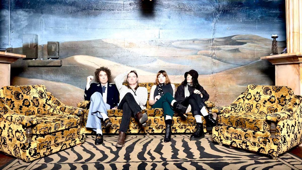 The Dandy Warhols seated on a sofa set against an ornate wall