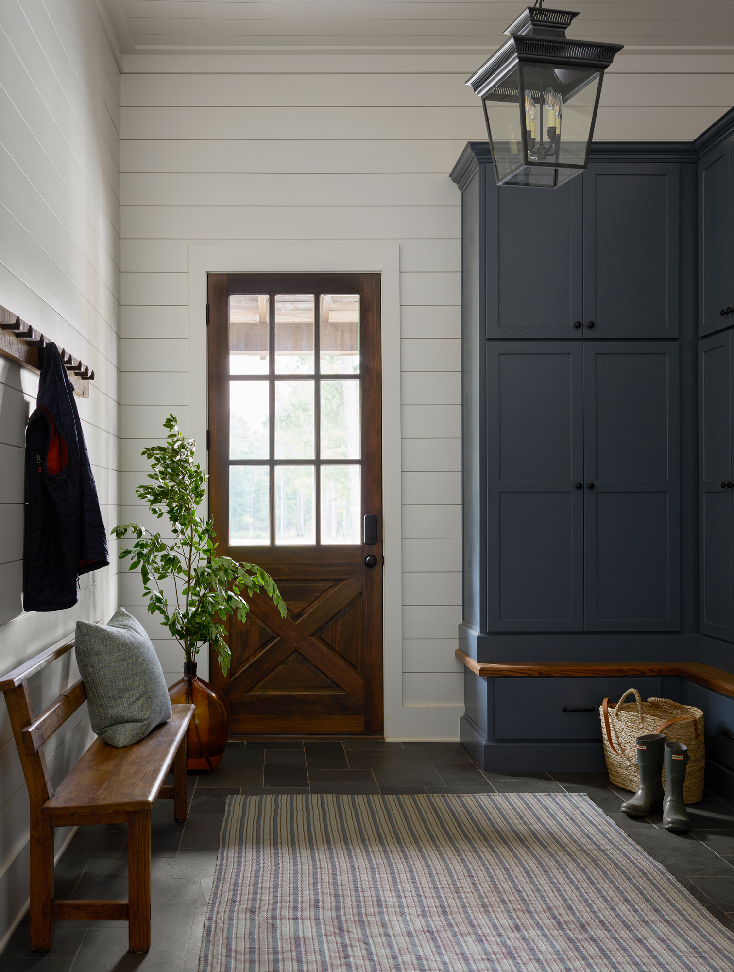 mudroom with blue cabinetry and a wooden bench