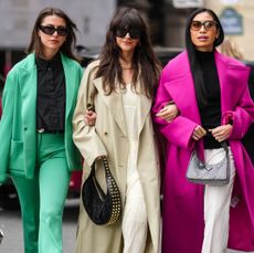 three women wearing three different types of coats