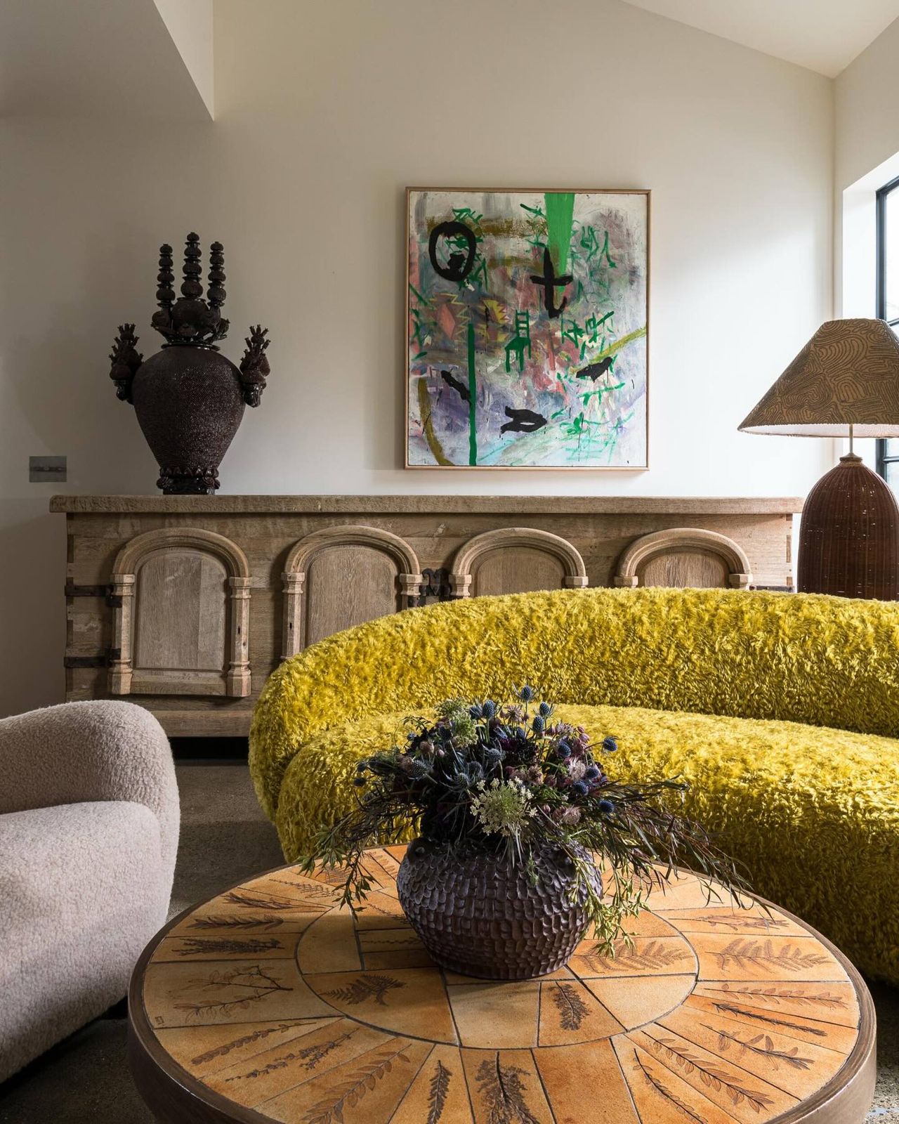yellow couch in a living room with neutral decor