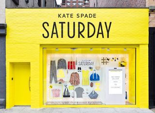 Bright yellow shop front with Kate Spade Saturday clothes pinned neatly to the wall
