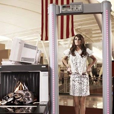 Woman Using Airport Security Scanner