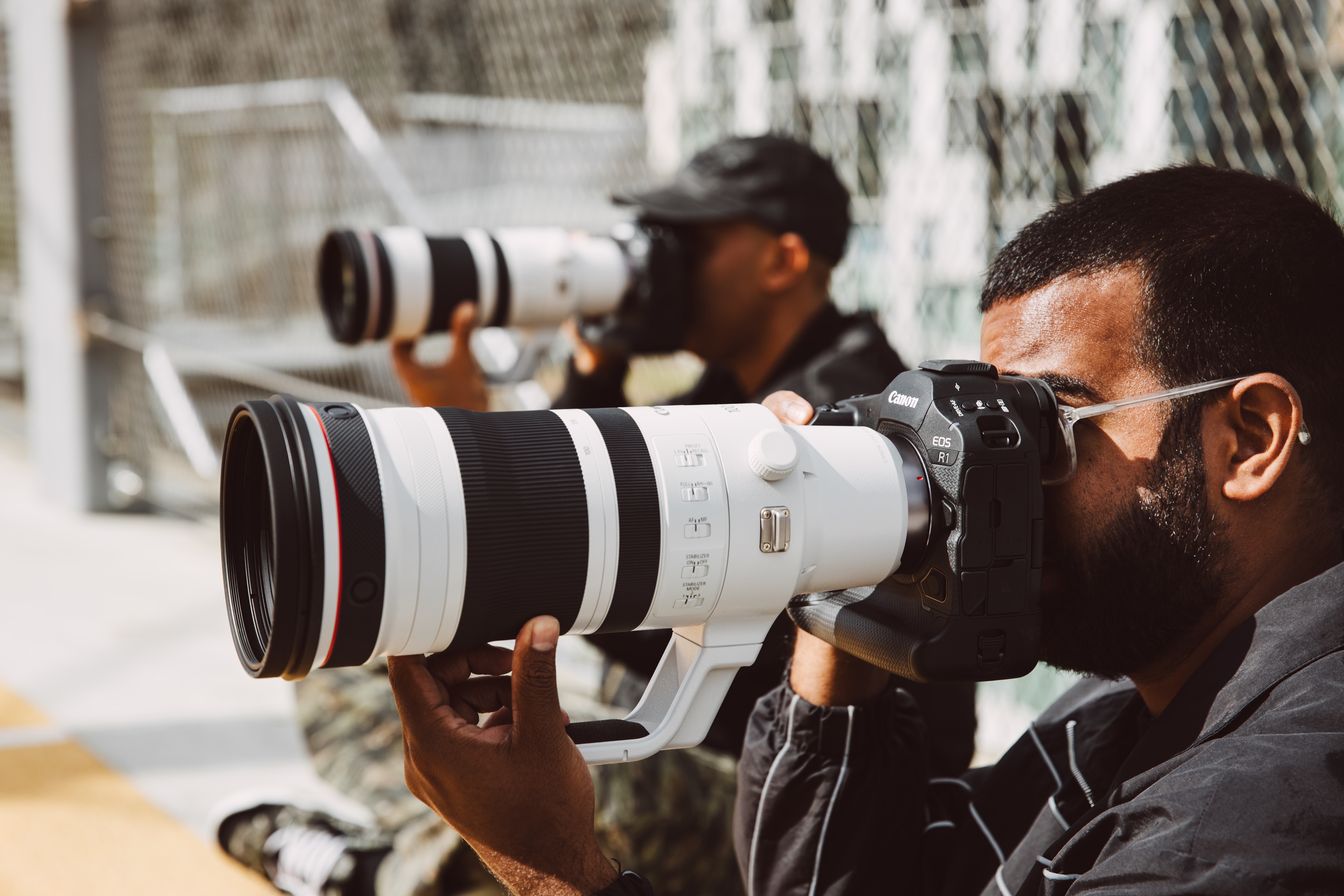 A person holding the Canon EOS R1 camera up to their eye