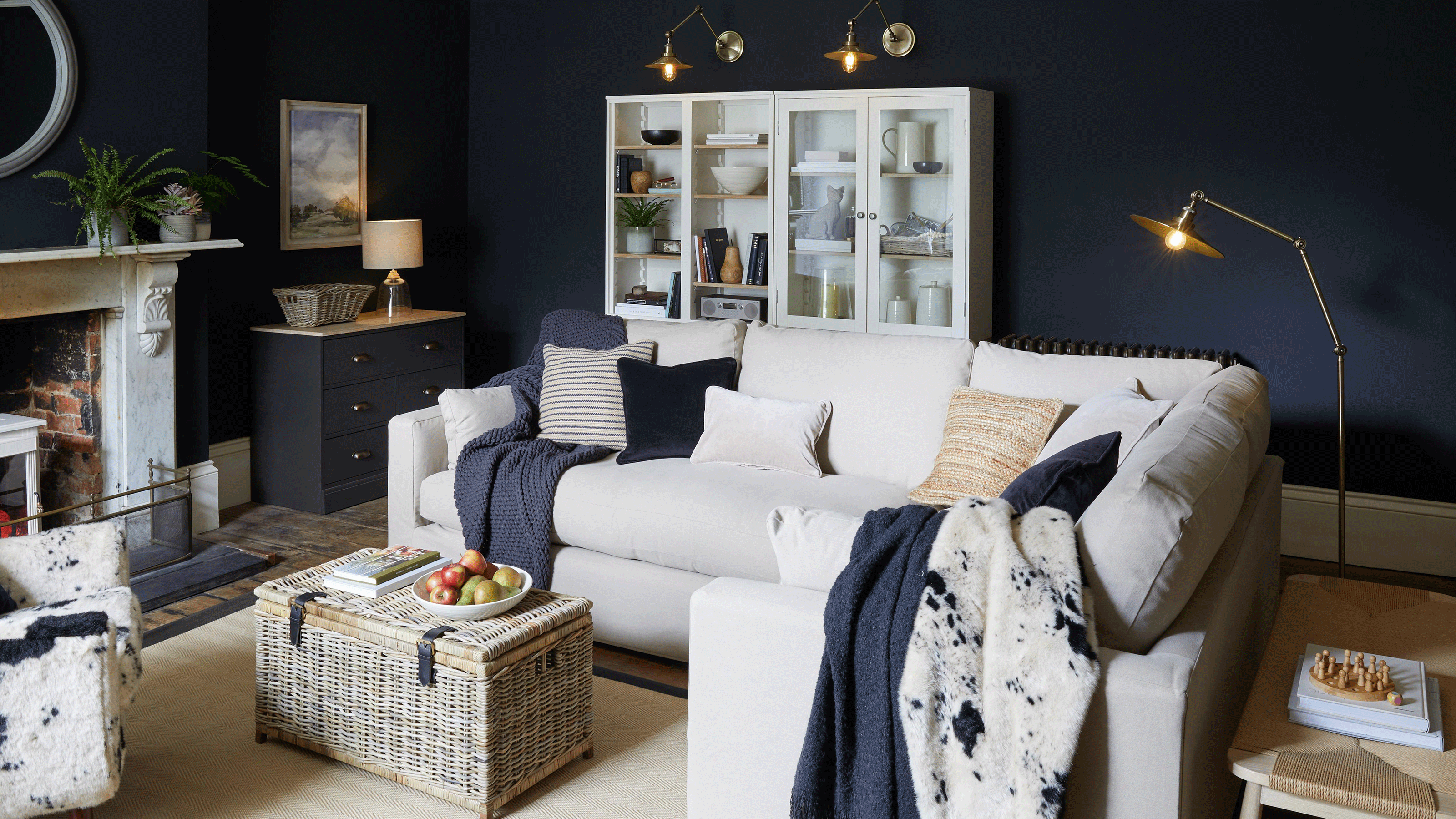 Arrange living room furniture to look chic like this blue and white one with variety of light sources including table lamp, floor lamp and wall sconces