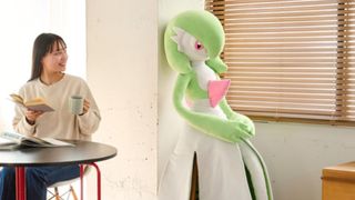 Gardevoir life-size plushie standing awkwardly as someone drinks their coffee