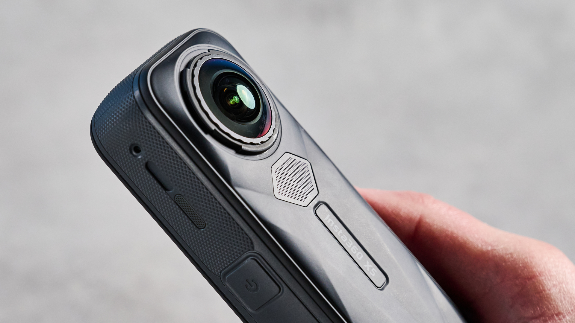 The Insta360 X5 in hand against a stone background