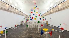 Installation in a former church made out of white pipes and colourful funnels