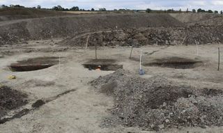 Archaeologists explore a pit site in England.
