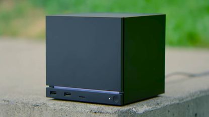 Steam Machine sitting on concrete with grass blurred in backdrop.