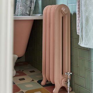 Bathroom with tiled patterned floor ad pink vintage radaitor.