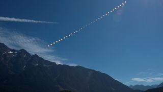 A composite image showing stages of a solar eclipse against a blue sky. 