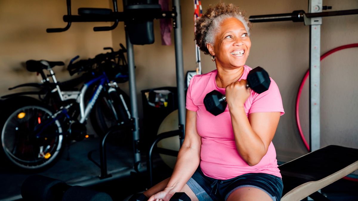 Woman exercises with dumbbells in garage gym