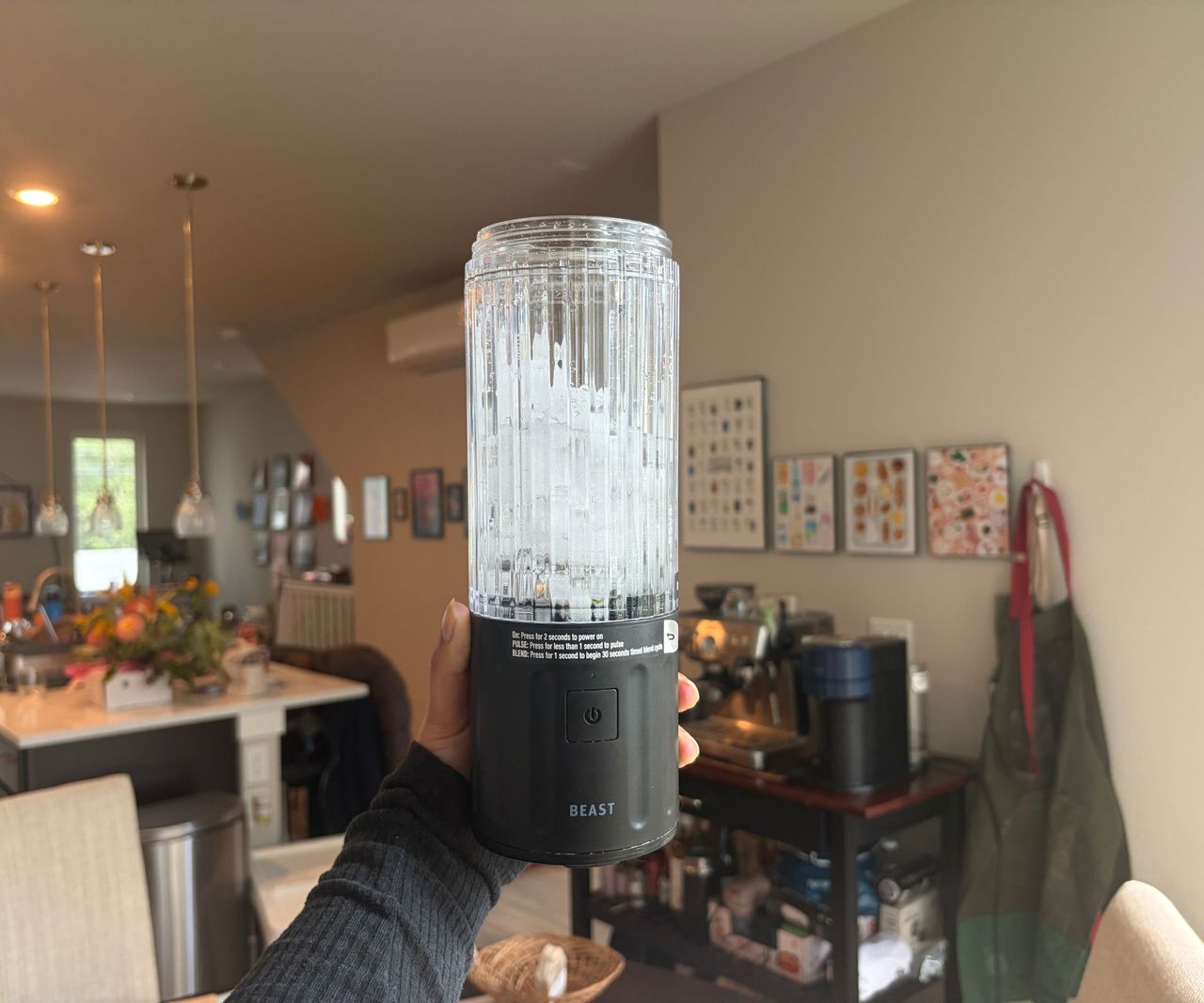 Chunks of ice inside a small clear pitcher blender with a grey base