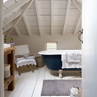 attic bathroom with blue bathtub and white walls