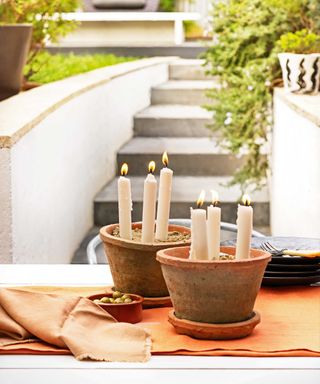 candles in pots on outdoor table