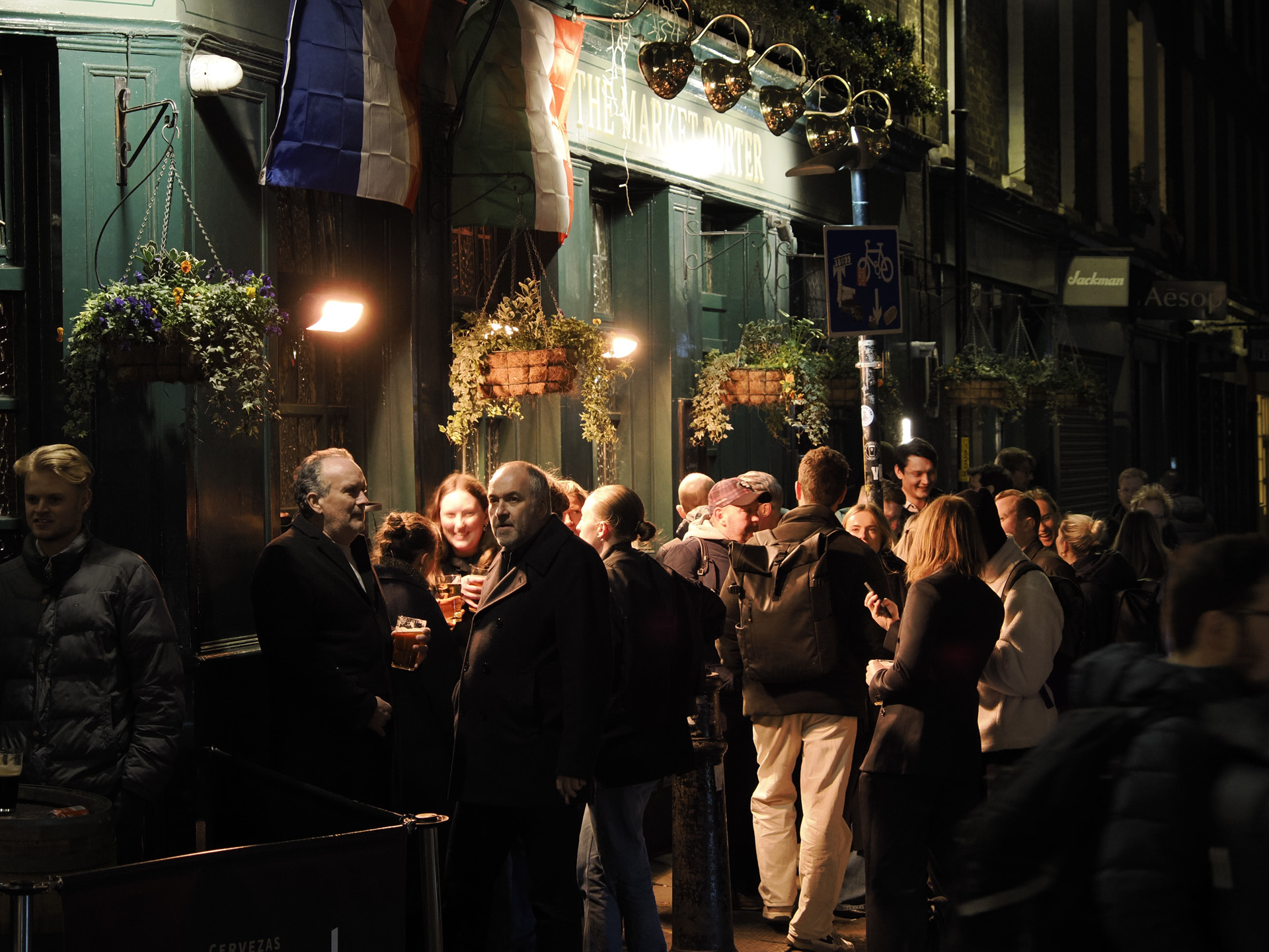 OM System OM-3 sample photos: crowded smoking area of a London pub at night