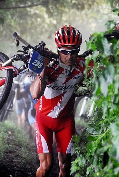 A Specialized rider carries his bike.