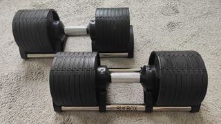 Closeup of the BLK BOX Adjustable Dumbbell on a carpeted floor