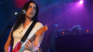 Amy Winehouse playing her red Fender Strat on stage
