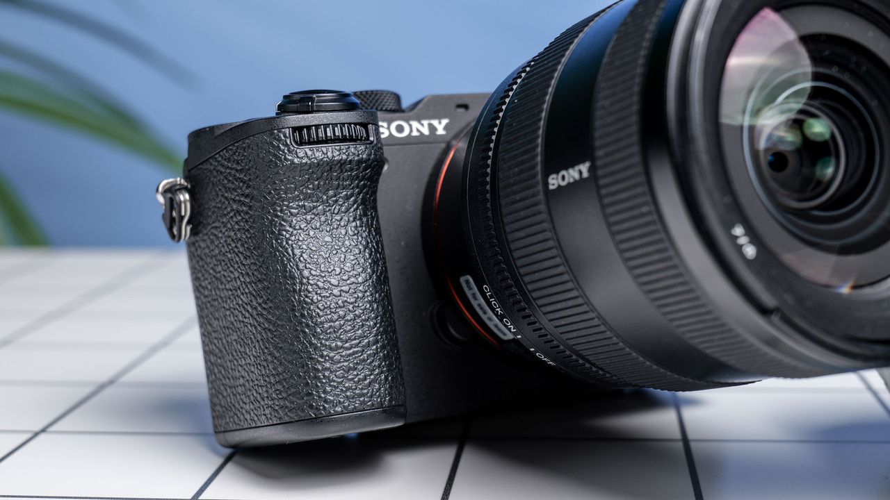 The Sony A7CR on a white table with a blue wall in the background