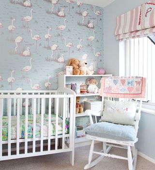nursery with flamingo print wallpaper and blue walls