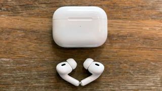The Apple AirPods Pro 2 on a wooden surface.