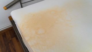 Image shows yellow sweat stains on a white memory foam mattress