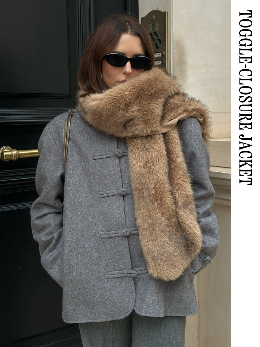 Woman wearing a gray toggle-closure jacket with a faux-fur scarf