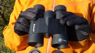 Person's hands holding Bushnell Prime 8x42 binoculars