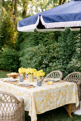 table dressed in garden with yellow flowers and matching tablecloth