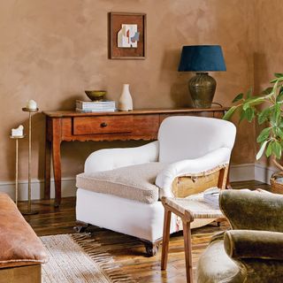 living room with hardwood floors, an antique console table and a reclaimed armchair