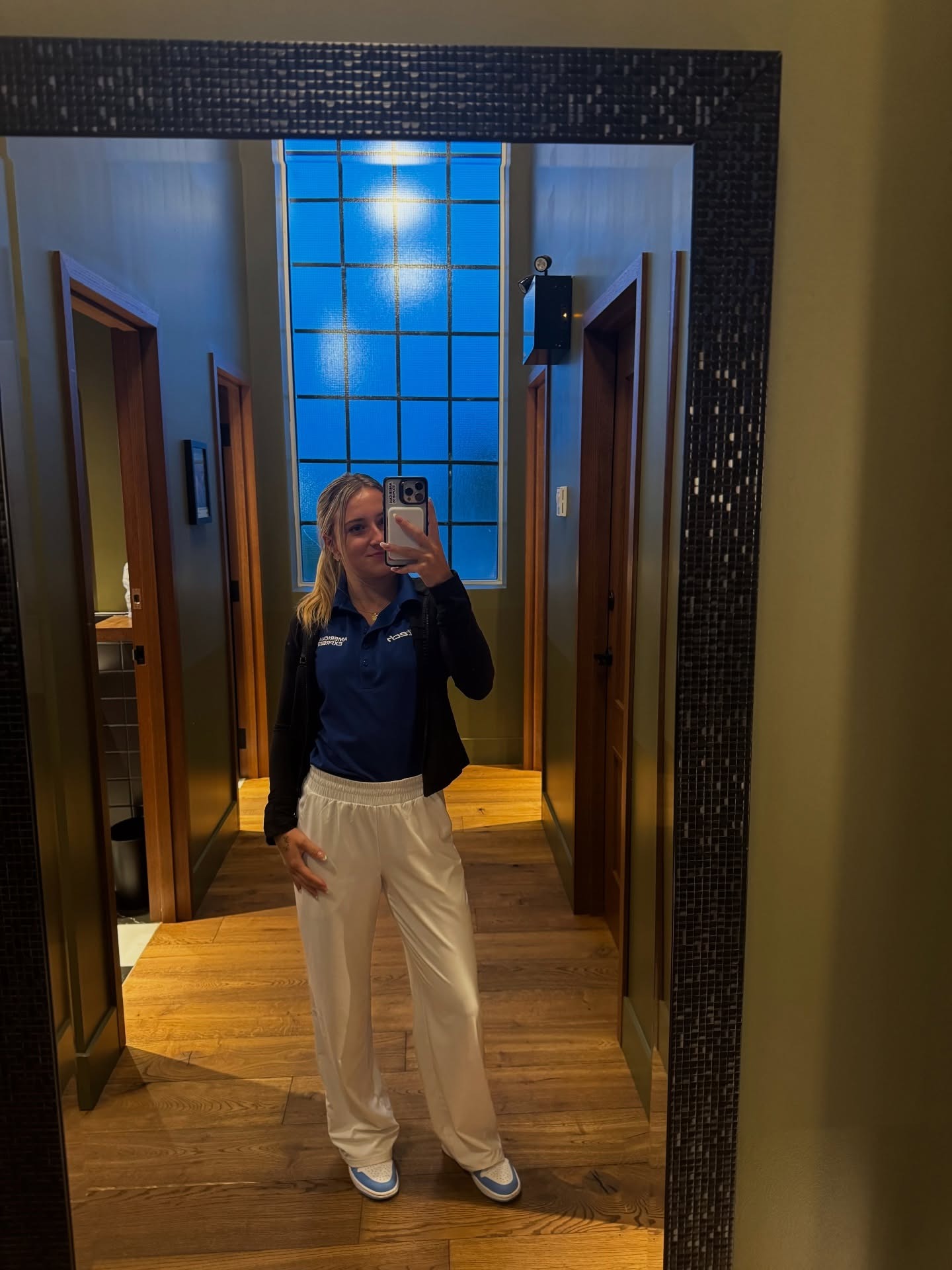 Nicole Havrda wearing a blue AMEX polo and white trousers.